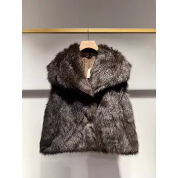A dark brown and black faux fur vest with a wide collar, hanging on a wooden hanger against a light gray wall.
