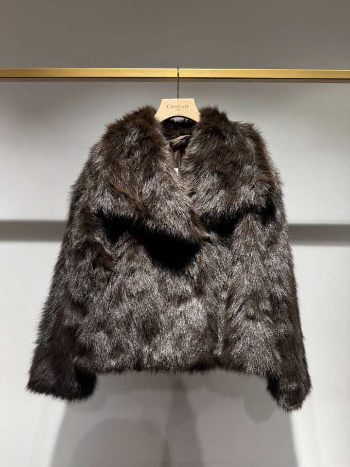 Fur coat on a hanger against a neutral background