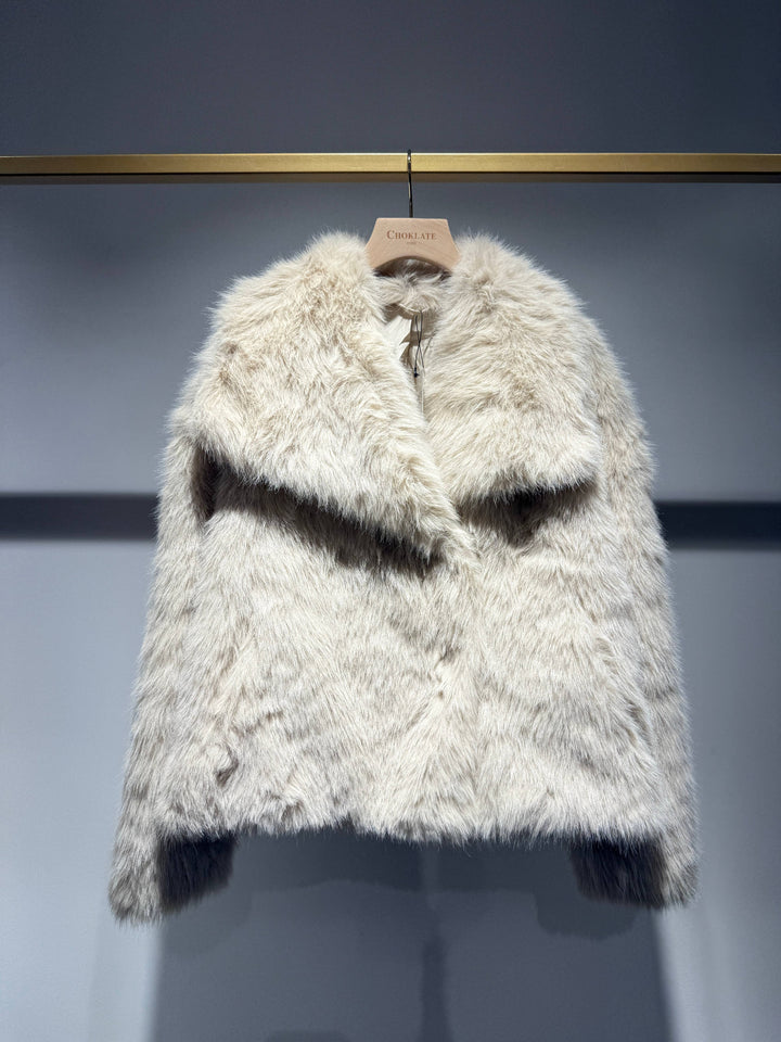 Furry white coat on a hanger against a gray background