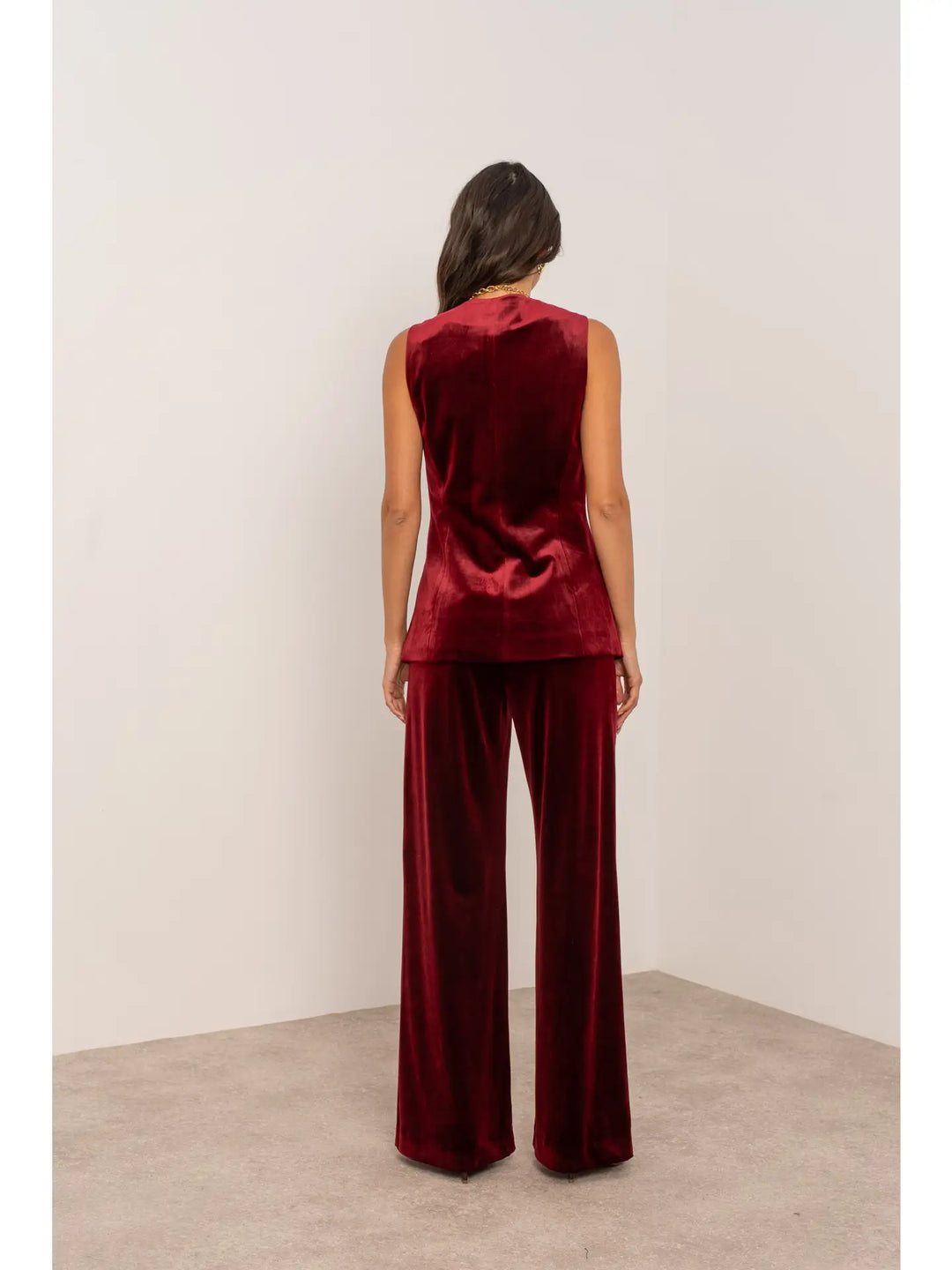 Person wearing a burgundy velvet outfit against a white background