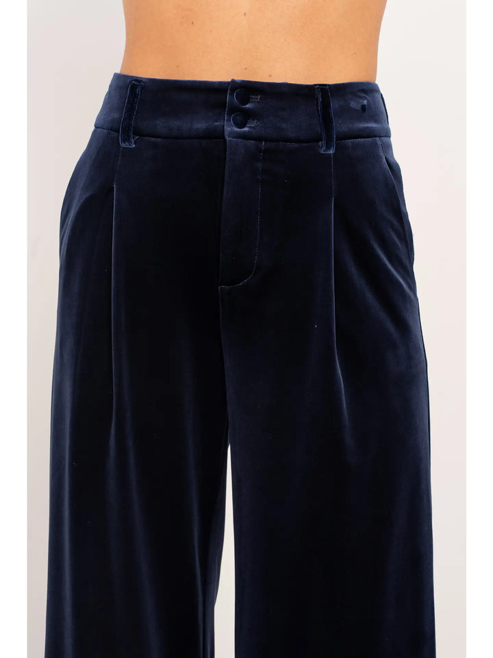 Navy velvet pants on a plain background