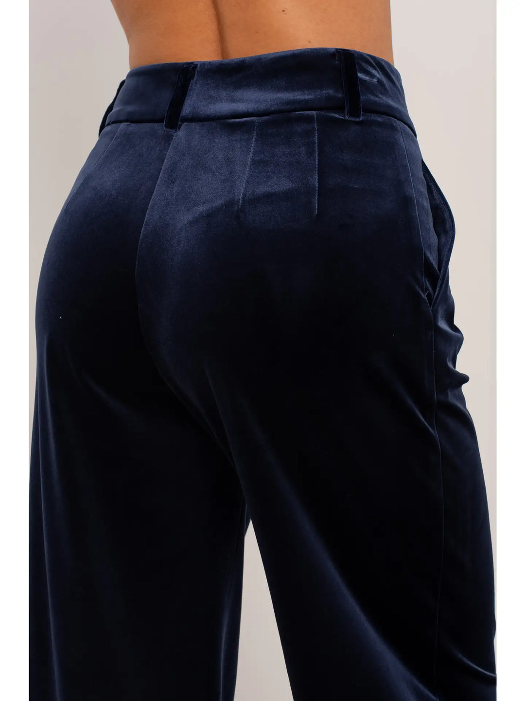 Navy blue pleated pants on a plain background