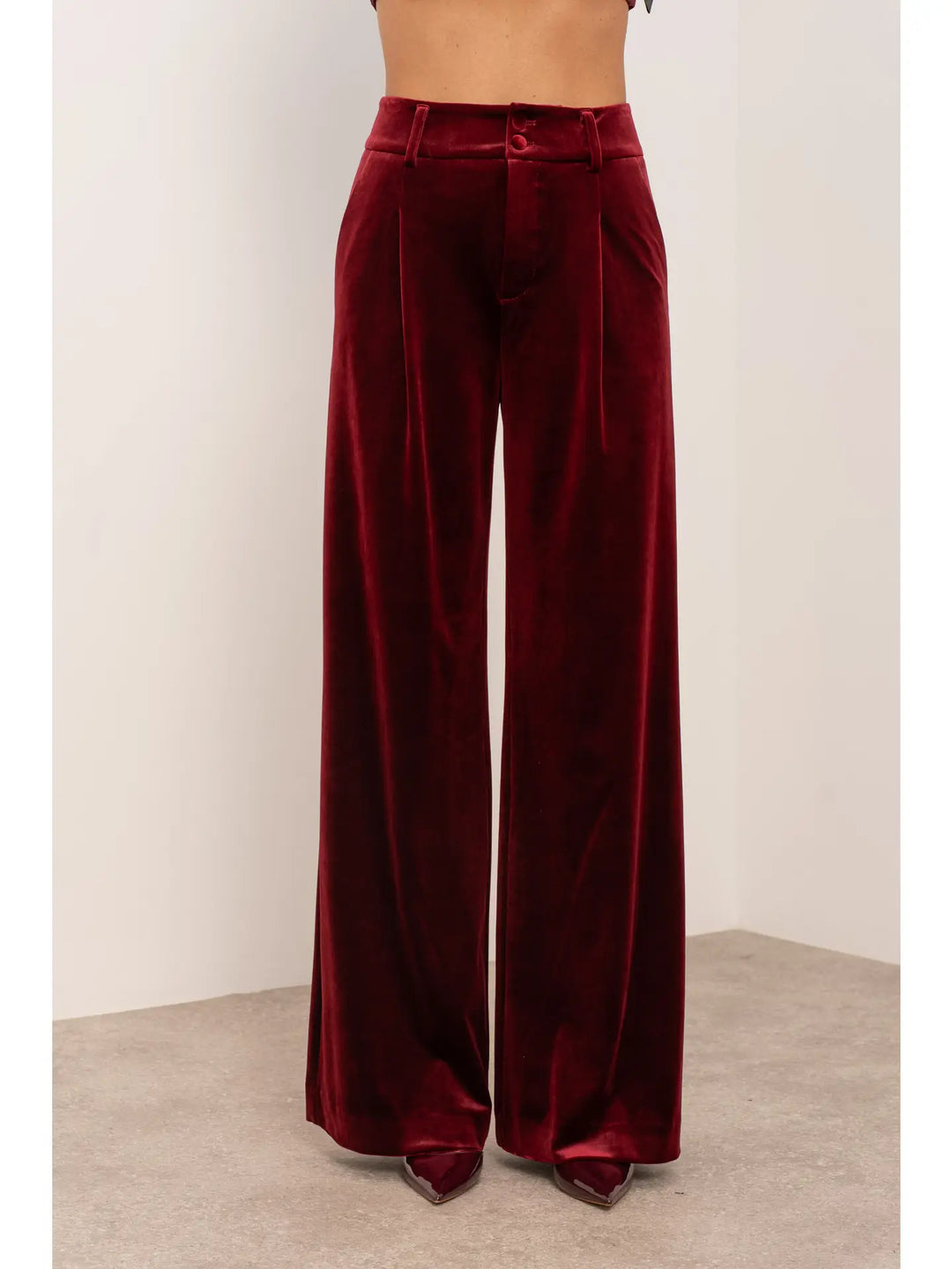 Maroon velvet wide-leg pants on a plain background