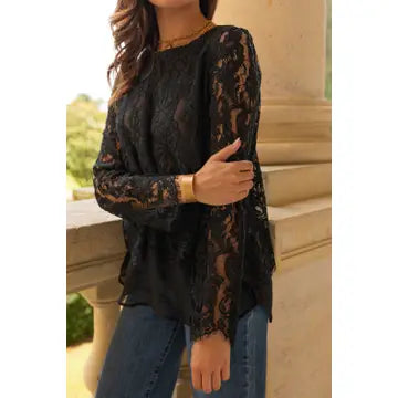 Person wearing a black lace top with long sleeves in an outdoor setting.