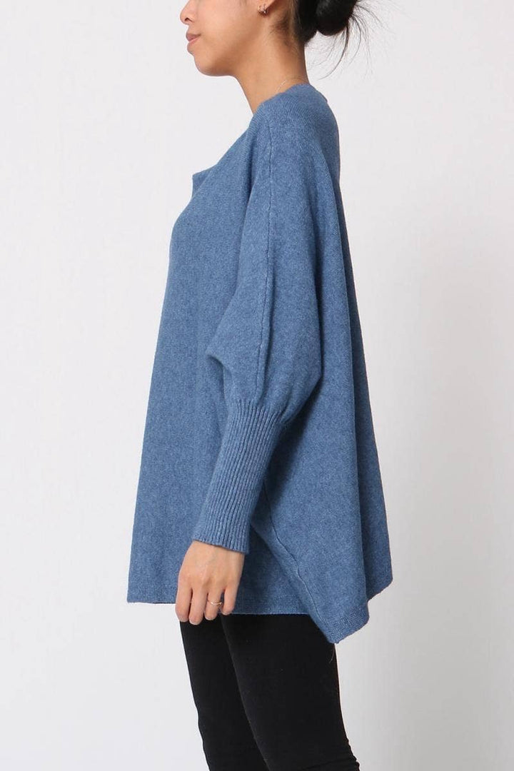 Person wearing a blue sweater against a white background