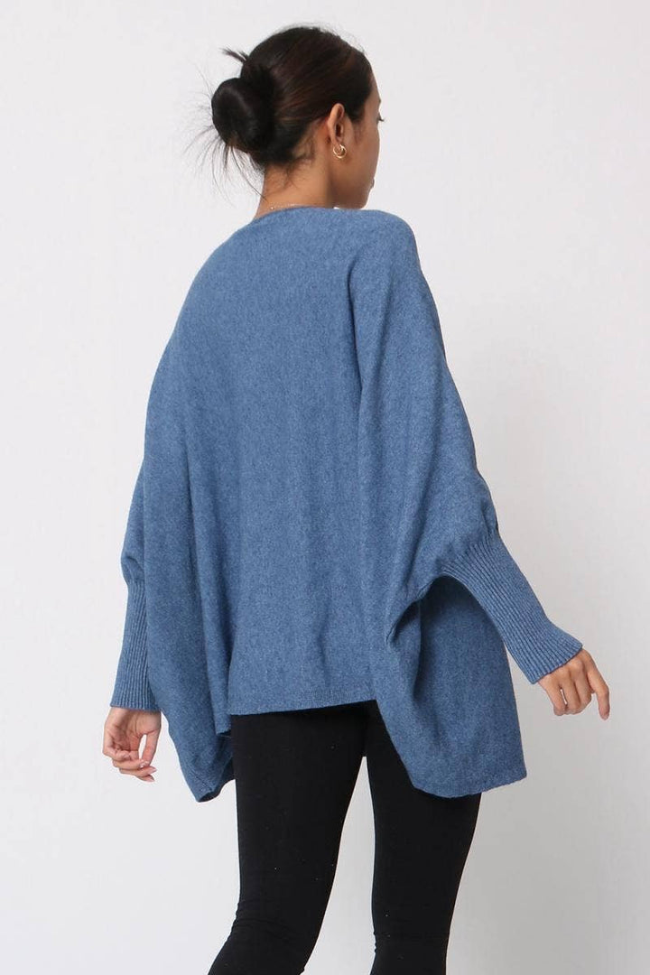 Person wearing a blue poncho against a white background