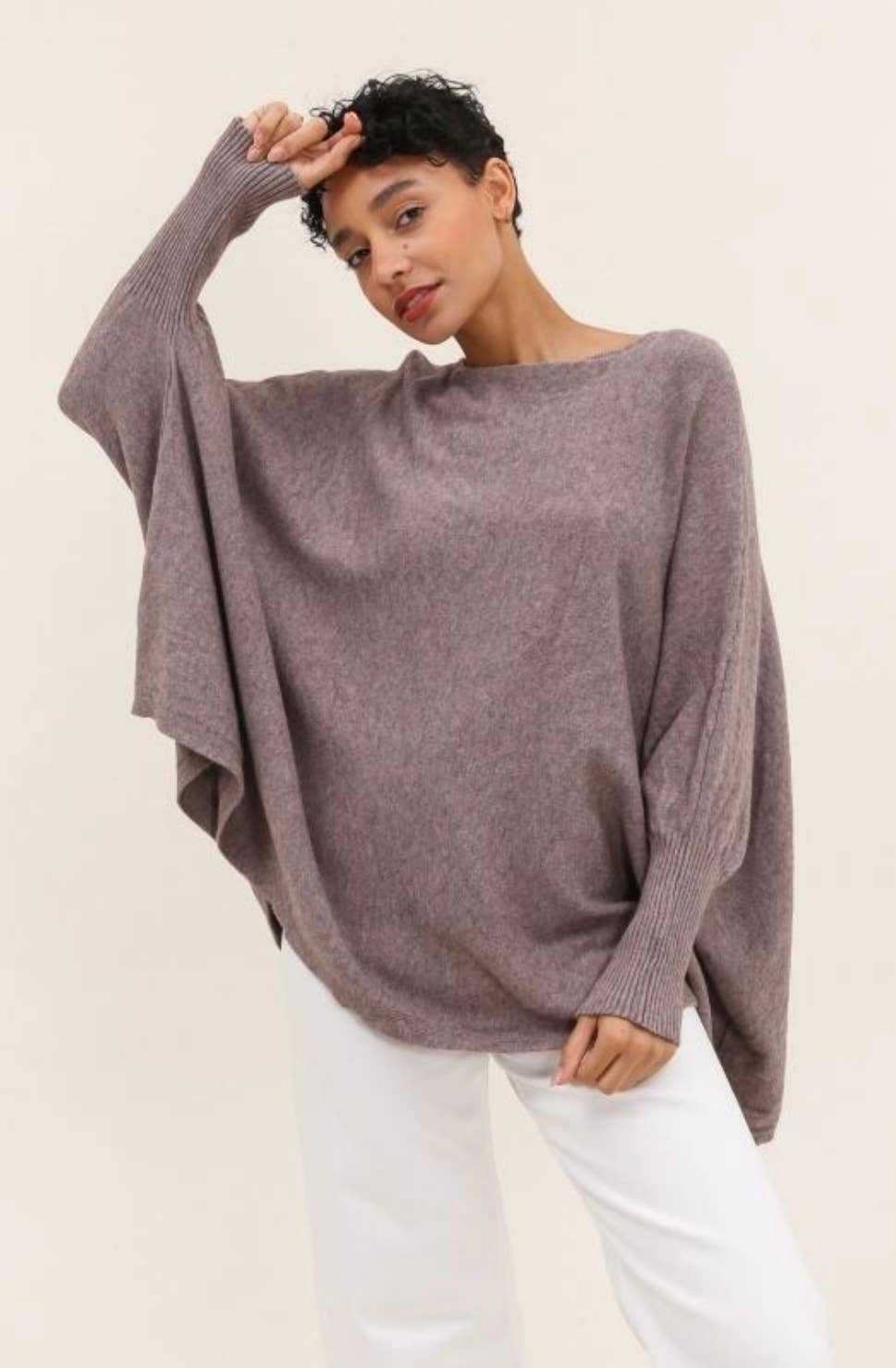 Woman wearing a loose-fitting purple sweater against a plain background