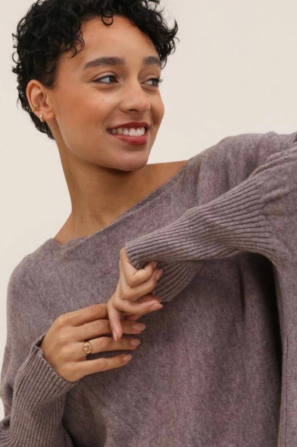 Woman wearing a purple sweater against a plain background