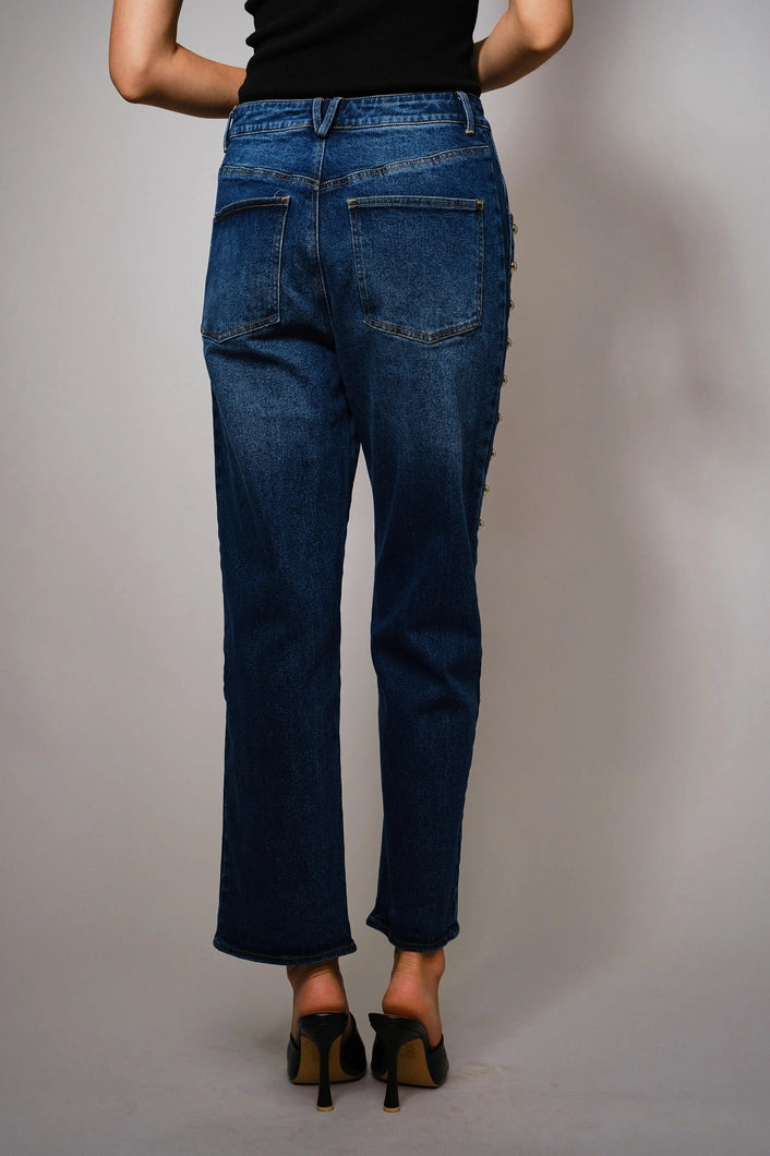 Person wearing blue jeans against a plain background
