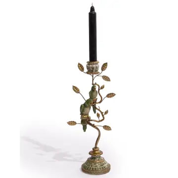 An ornate bronze and green metal candlestick holder shaped like a tree branch with two small bird figures, holding a single black taper candle, shown against a plain white background.