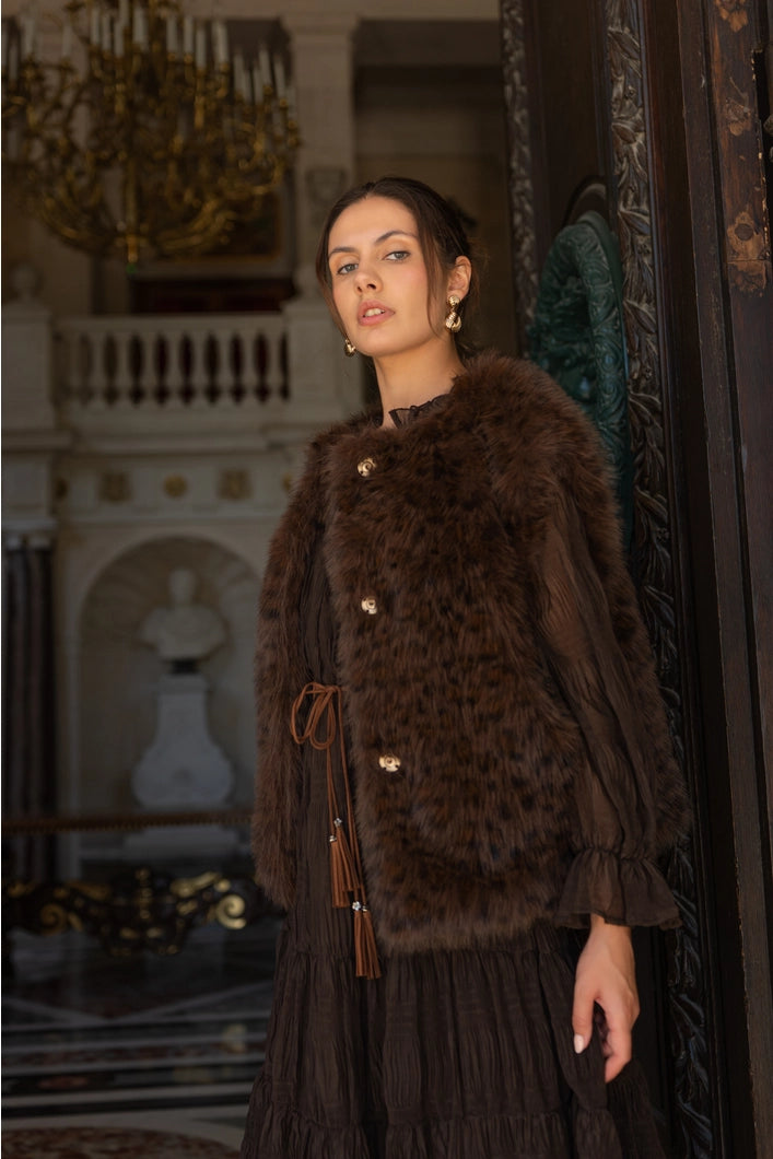 Woman wearing a brown fur coat in an elegant interior setting