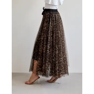 A model wearing a brown and black leopard print tulle midi skirt with a black waistband, paired with clear high-heeled sandals.