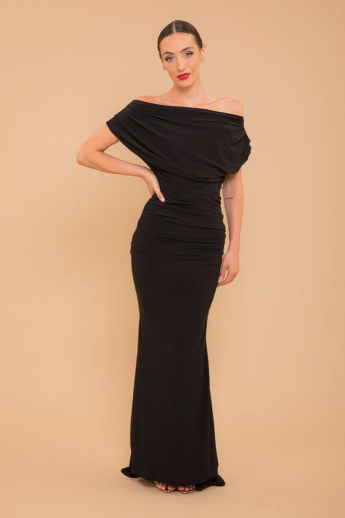 Woman wearing a black off-shoulder gown against a beige background