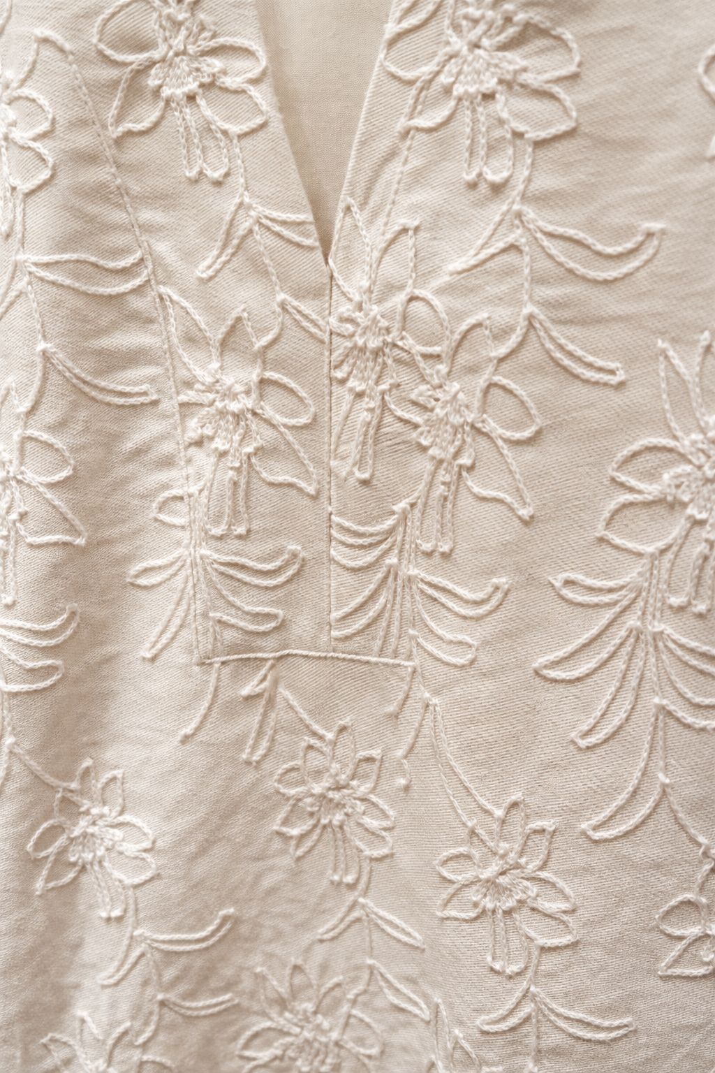 Close-up of a beige fabric with floral embroidery