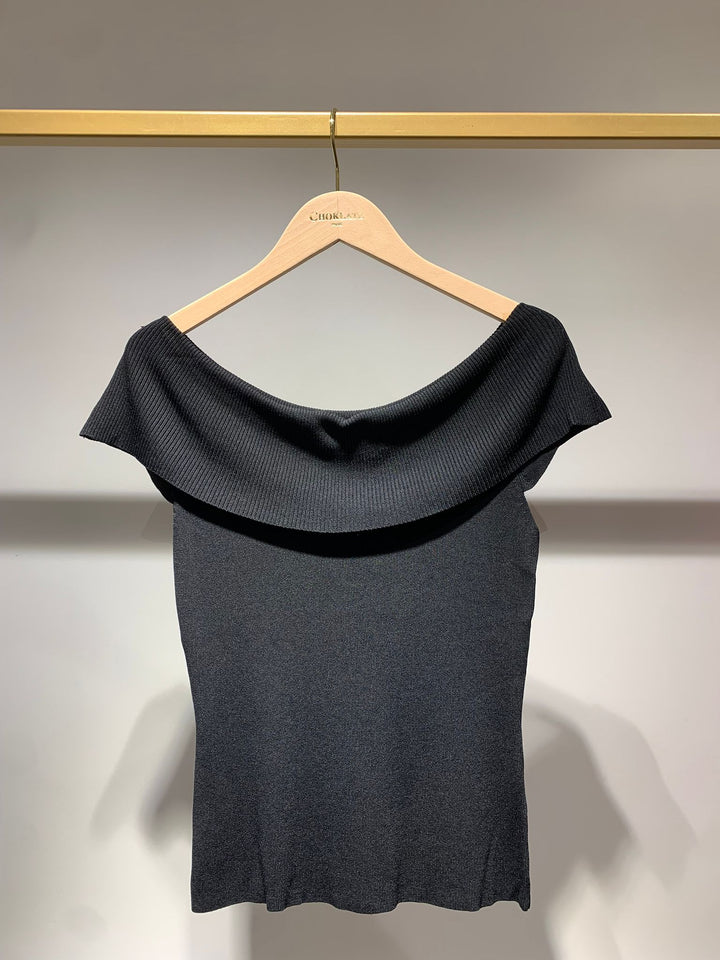 Black top on a hanger against a neutral background