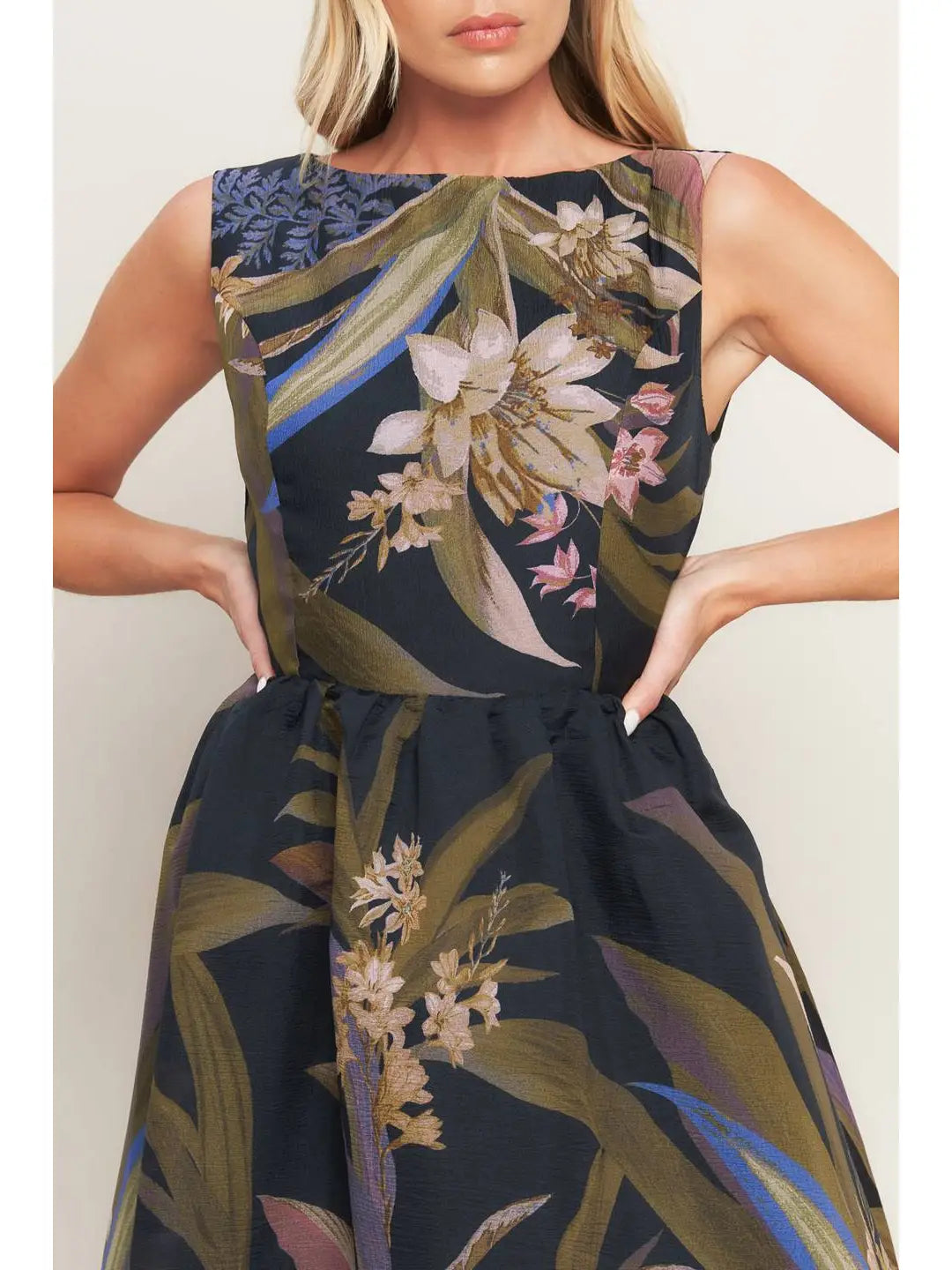 Woman wearing a dark floral dress against a plain background