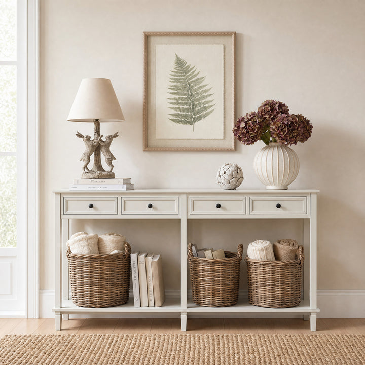 White console table with decorative items including a lamp, framed artwork, and baskets in a room.