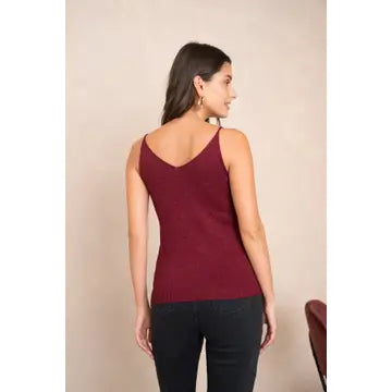 Woman wearing a burgundy tank top against a beige background