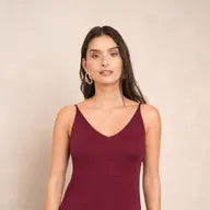 Woman wearing a burgundy dress against a beige background