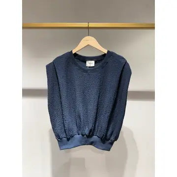 Blue sweatshirt on a hanger against a neutral background