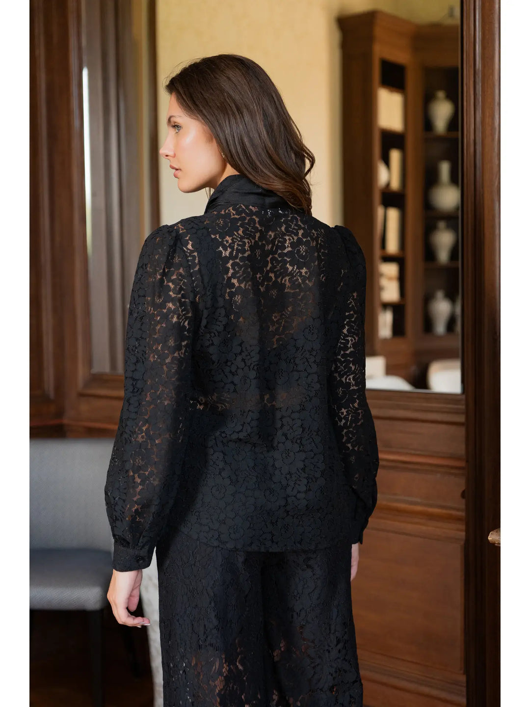 Woman wearing a black lace outfit in an indoor setting