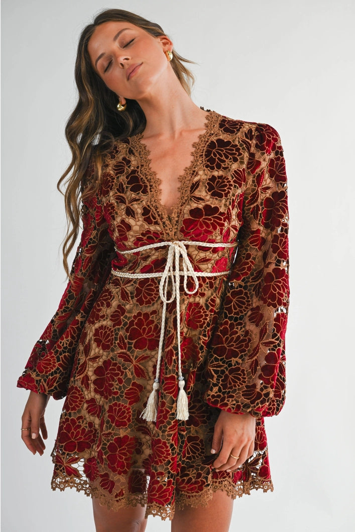 Woman wearing a floral dress with long sleeves on a plain background