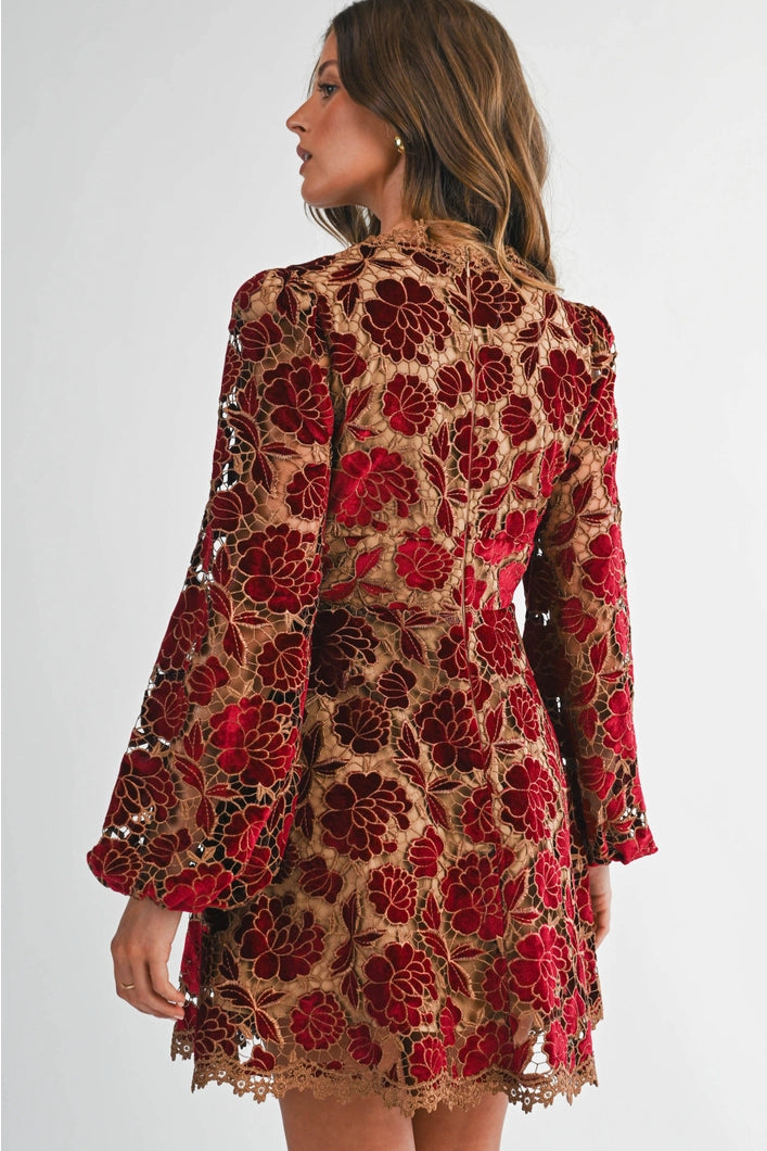 Woman wearing a floral dress with red and brown pattern on a white background