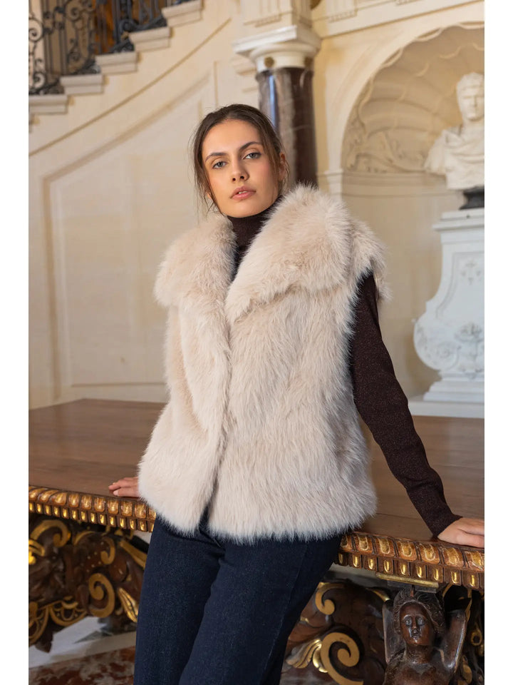 Woman wearing a white fur vest in an elegant interior setting