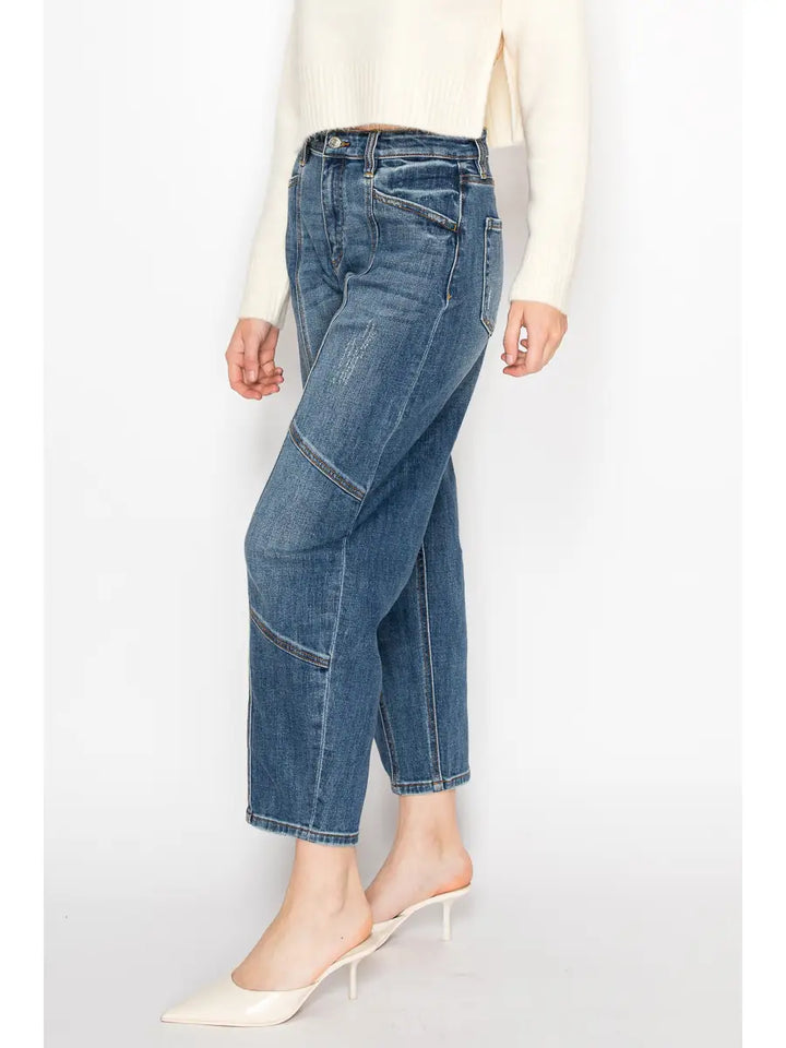 Person wearing blue jeans and a white top on a light gray background