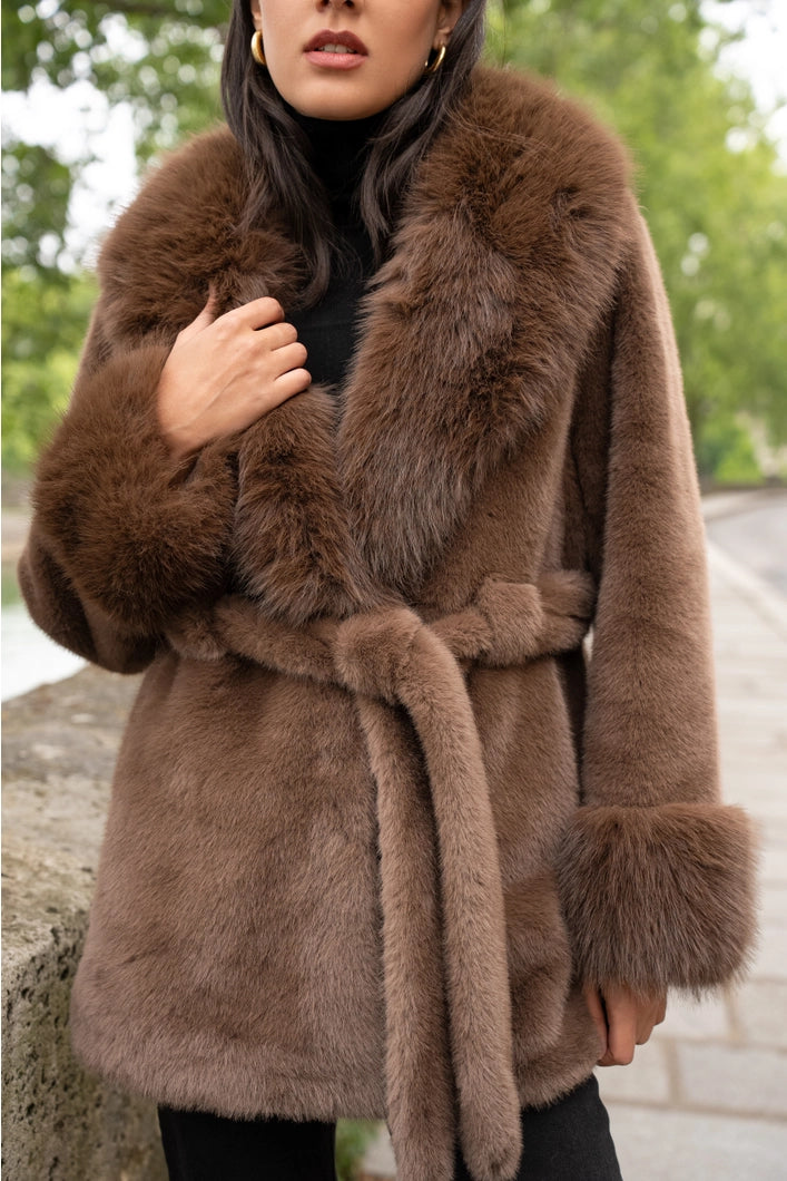 Brown fur coat with a belt worn by a person outdoors.
