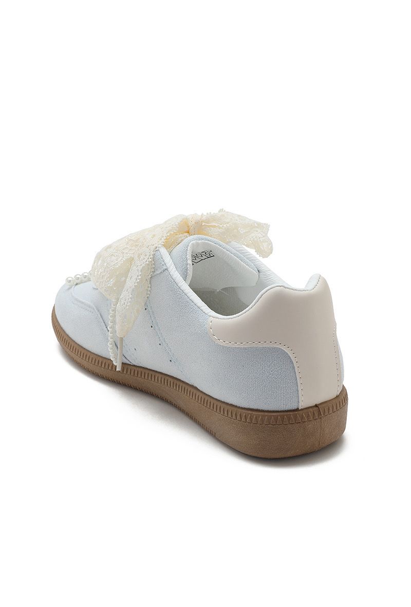 White sneaker with a bow detail on a white background