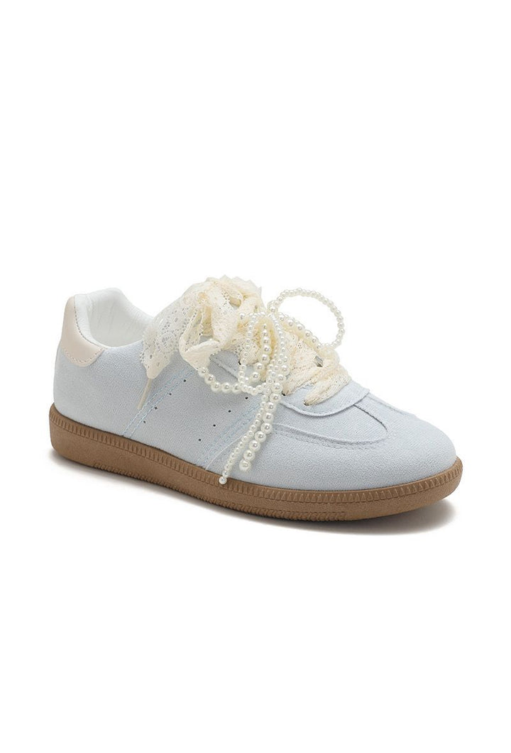 White sneaker with pearl-like laces on a white background