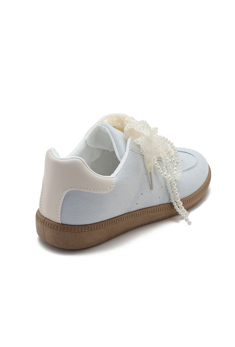 White sneaker with a brown sole on a white background