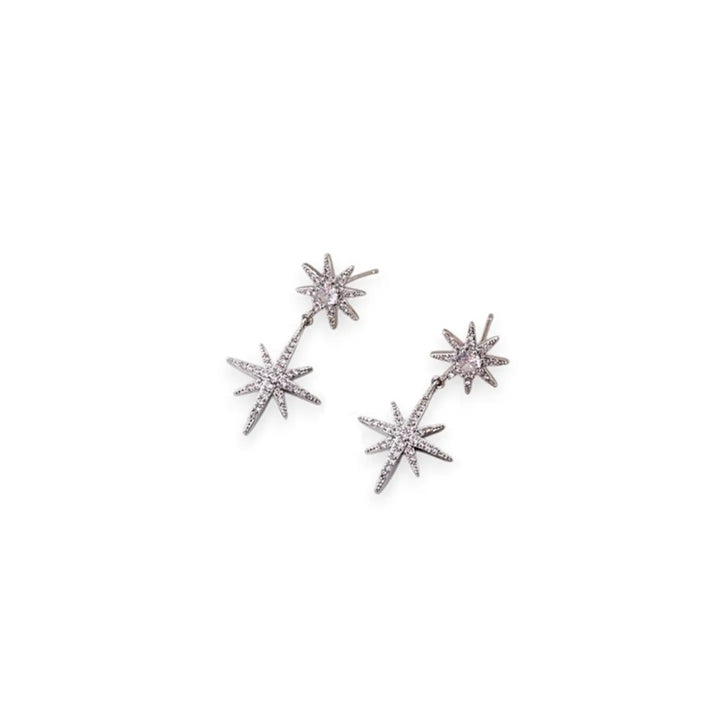 A pair of silver-toned dangle earrings featuring three-pointed starburst charms set with small clear stones and a central round pale pink stone, shown on a plain white background.