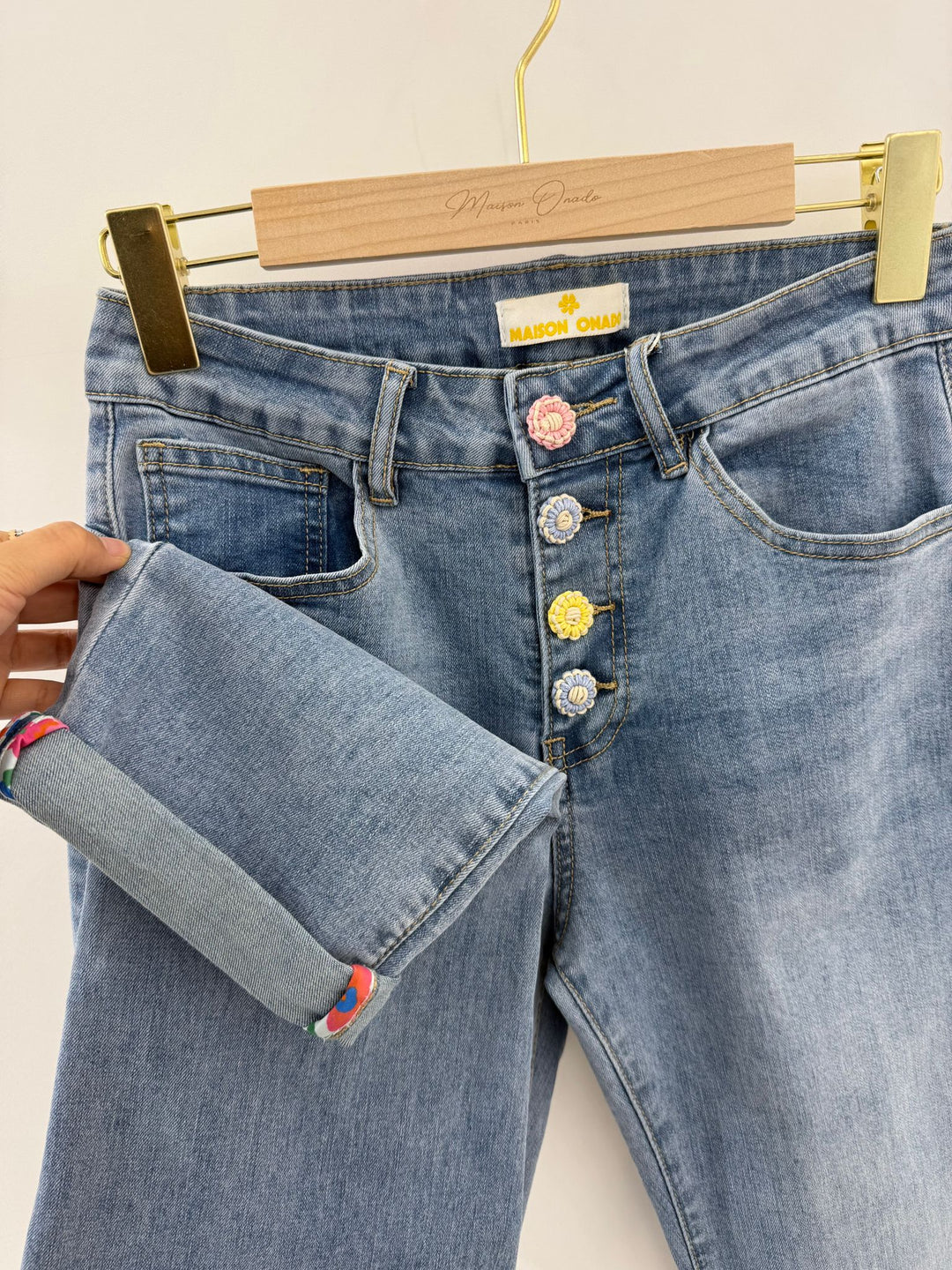 Blue jeans with decorative buttons on a hanger