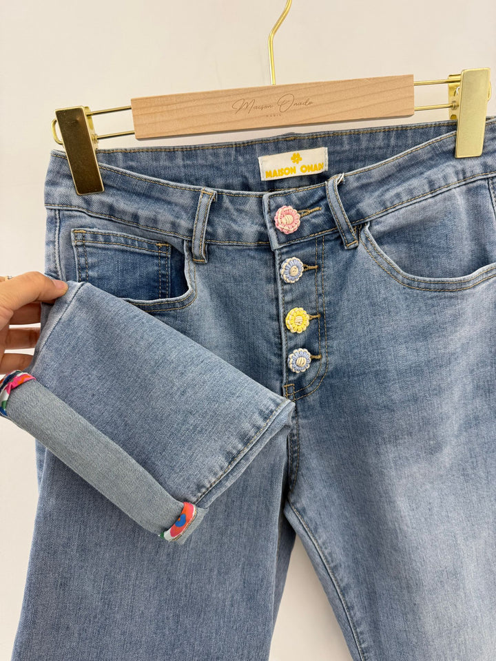 Blue jeans with decorative buttons on a hanger