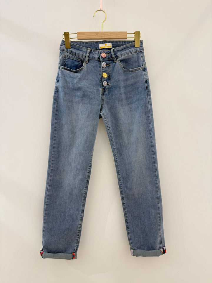 Blue jeans on a hanger against a plain background
