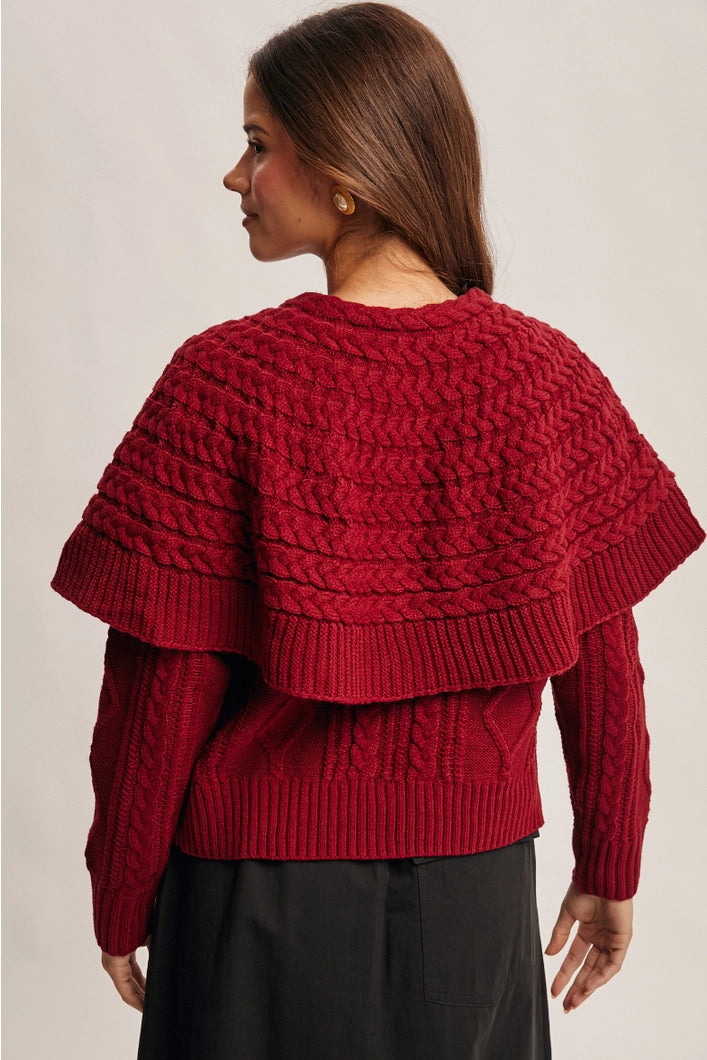 Woman wearing a red knitted sweater against a neutral background