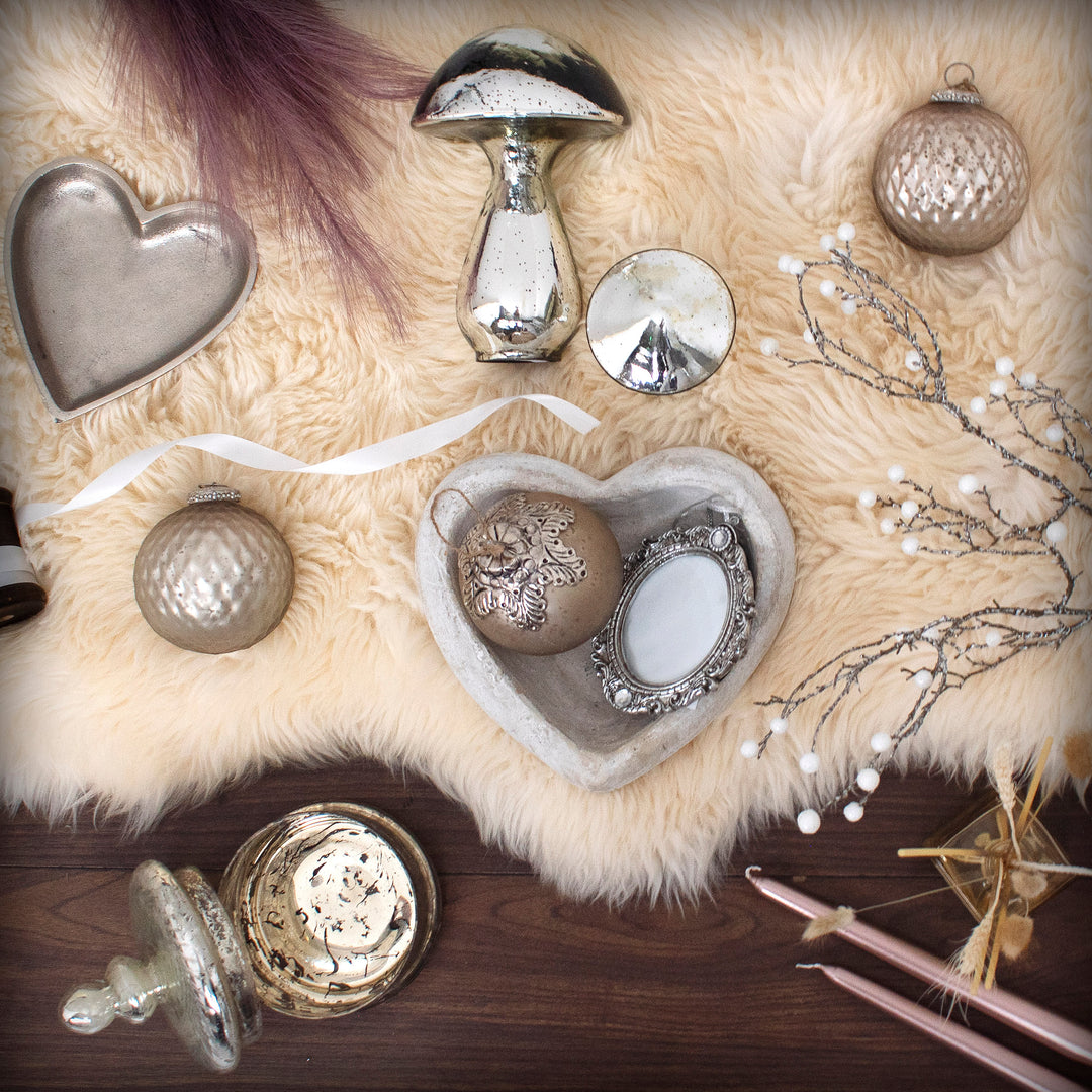 Decorative items including a heart-shaped object, mushrooms, and ornamental balls on a textured surface.