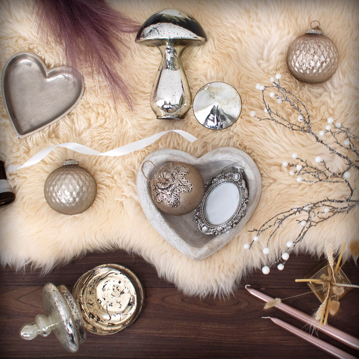 Decorative items including a heart-shaped object, mushrooms, and ornamental balls on a textured surface.