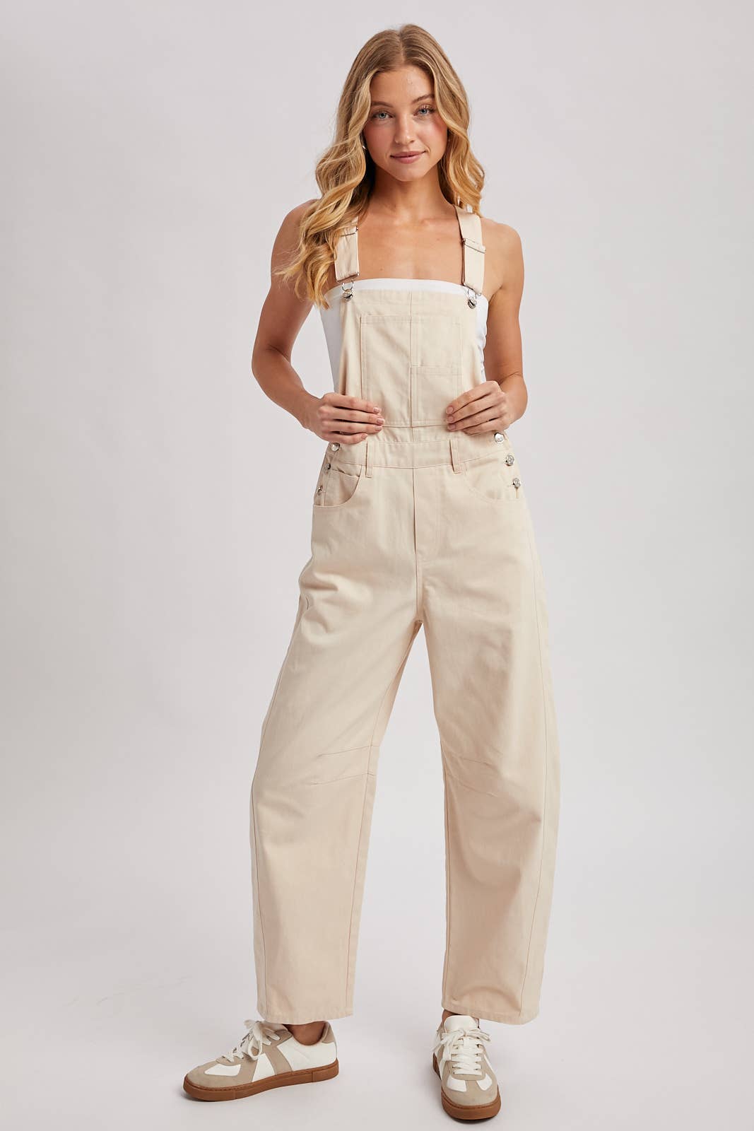 Woman wearing beige overalls on a white background