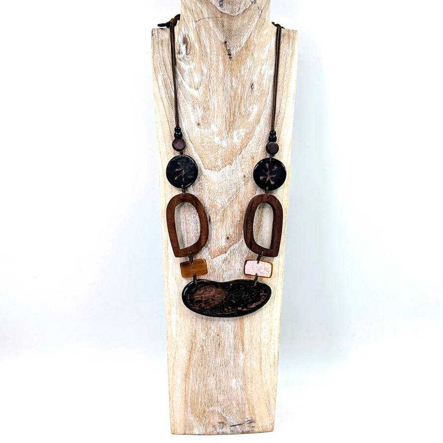 Necklace with brown and black pendant on a wooden stand against a white background