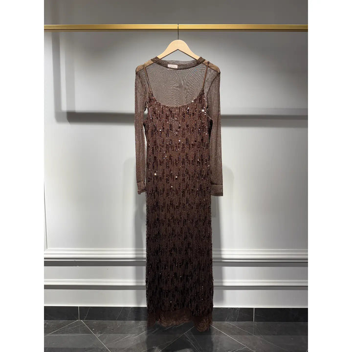 Long dark brown dress with sequin details on a hanger against a gray wall.