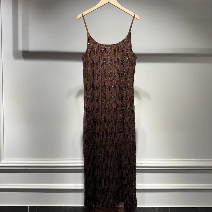 Brown sequin dress on a hanger against a gray wall.