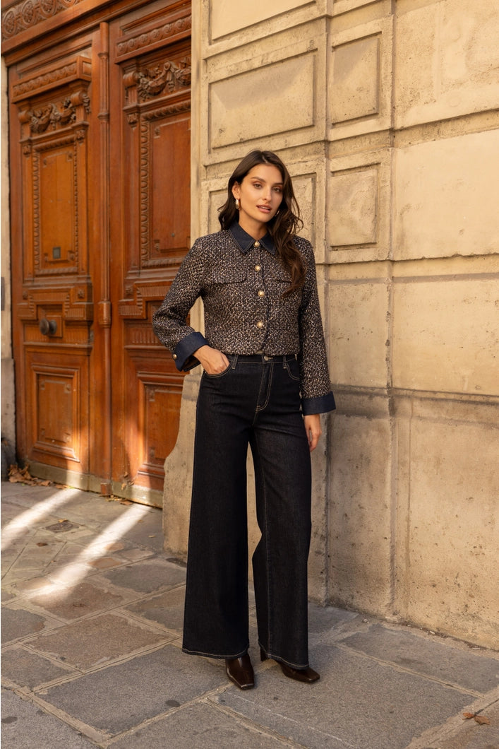Woman standing in front of a textured wall and wooden door