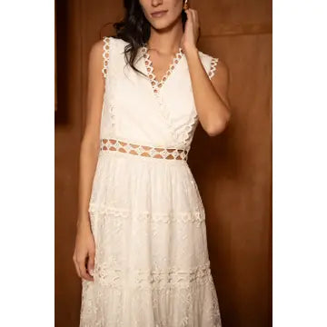 White lace dress worn by a model against a brown background