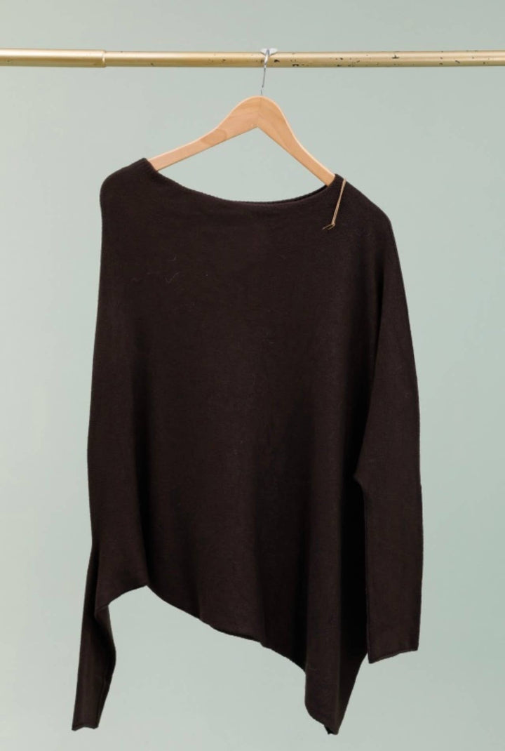 Brown sweater on a hanger against a light green background