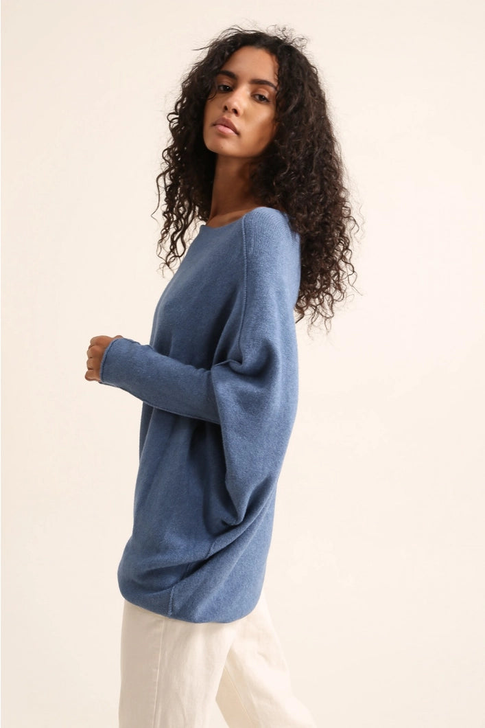Woman wearing a blue sweater on a beige background