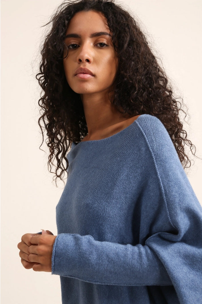 Woman wearing a blue sweater against a plain background