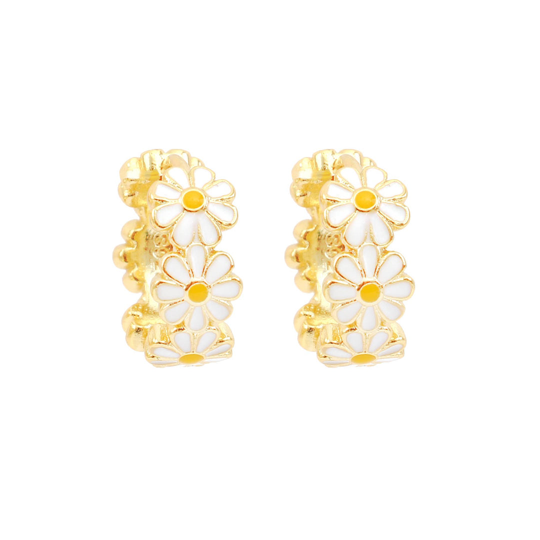 Gold hoop earrings with white floral designs on a white background